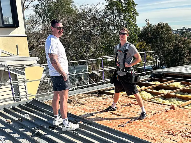 Jackson Barnes with a Barnes Family Roof Plumbing apprentice on a re-roof, the old roof stripped back