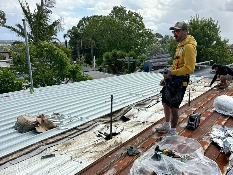 A Barnes Family Roof Plumbing roof plumber on the tools, replacing an old rusted metal roof