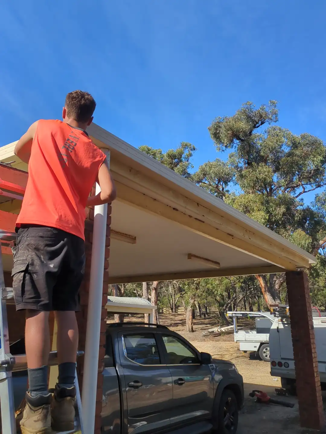 A Barnes Family Roof Plumbing roof plumber on a ladder fitting a new gutter